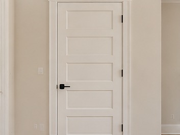 Finished interior door with wide painted casing, baseboard and crown molding